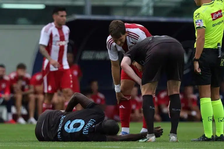 Lukaku couché se tient la cuisse gauche