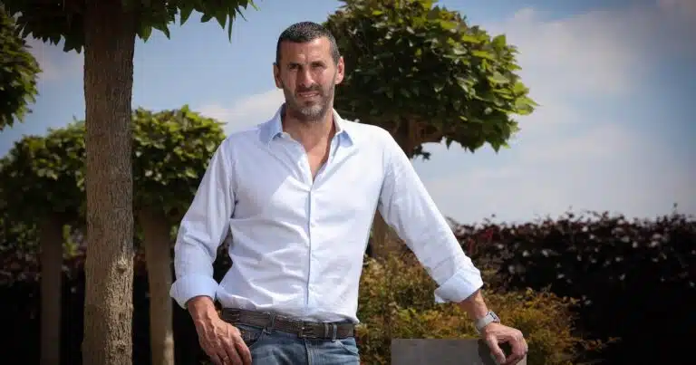 Jacky Peters pose pour une photo avec en arrière plan un arbre